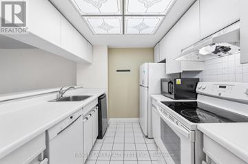 Toronto (Bay Street Corridor) condo for rent - A white kitchen with a stove top oven and a microwave.