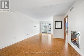 Toronto (Bay Street Corridor) condo for rent - A spacious room with a fireplace and a painting on the wall.
