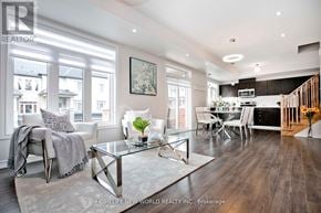 Pickering (Duffin Heights) townhouse for rent - A modern living room with a glass coffee table and a staircase in the background.