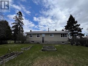 Richards Landing apartment for rent - A house with a grey roof and a grey wall with a small garden in front.
