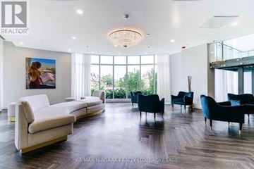Niagara Falls (Oldfield) condo for rent - A living room with a white couch and a painting of a woman on the wall.