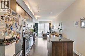 Kitchener condo for rent - A modern kitchen with a refrigerator covered in magnets and a long island in the middle.
