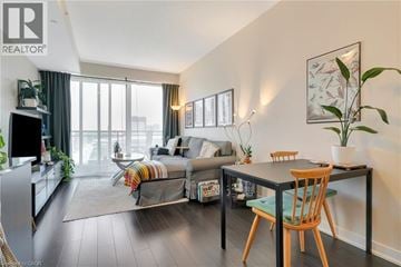 Kitchener condo for rent - A living room with a grey couch and a wooden table.