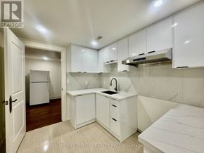 Toronto (Willowdale East) apartment for rent - A white kitchen with a refrigerator, sink, and cabinets.