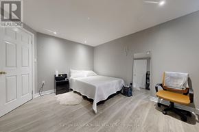 Barrie (Painswick South) apartment for rent - A bedroom with a bed, chair, and suitcase.