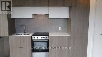 Toronto (Church-Yonge Corridor) condo for rent - A kitchen with a stove, sink, and cabinets.