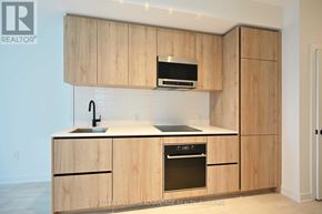 Toronto (Mount Pleasant West) condo for rent - A kitchen with wooden cabinets and a black microwave above the stove.