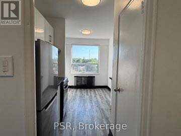 Toronto (Forest Hill North) condo for rent - A kitchen with a refrigerator and a door leading to a hallway.