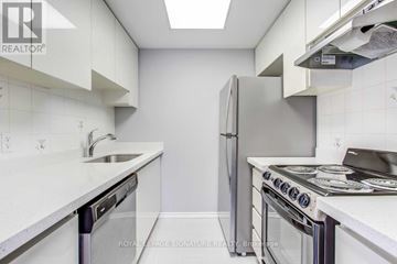 Toronto (Church-Yonge Corridor) condo for rent - A kitchen with white cabinets and a stainless steel refrigerator.