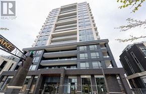 Grimsby (Grimsby Beach) condo for rent - A tall building with a glass facade stands in front of a smaller building with a brick facade.