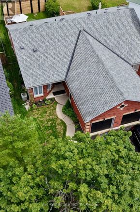 Peterborough (Monaghan Ward 2) townhouse for rent - A house with a grey roof surrounded by trees.