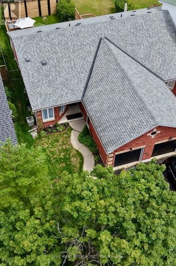 Peterborough (Monaghan Ward 2) townhouse for rent - A house with a grey roof surrounded by trees.