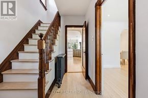 Toronto (Leaside) apartment for rent - A hallway with a staircase and a mirror on the wall.