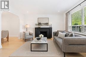 Toronto (Leaside) apartment for rent - A living room with a grey couch, a fireplace, and a painting on the wall.