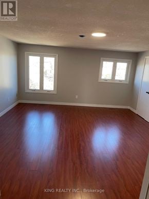 Markham (Middlefield) apartment for rent - A room with wooden floors and two windows.