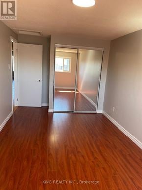 Markham (Middlefield) apartment for rent - A room with wooden floors and a sliding glass door leading to a balcony.
