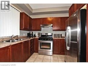 Ancaster townhouse for rent - A kitchen with wooden cabinets and stainless steel appliances.