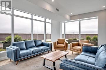 Peterborough (Ashburnham Ward 4) condo for rent - A living room with a blue couch and brown armchairs.