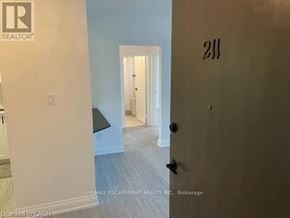 Hamilton (Ainslie Wood) condo for rent - A room with a door numbered 211 and a brokerage logo.