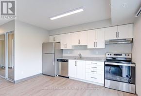 Kitchener multi-family for rent - A kitchen with white cabinets and stainless steel appliances.