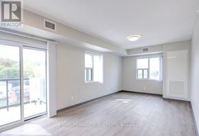 Kitchener multi-family for rent - A spacious room with a sliding glass door leading to a balcony.