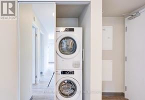 Kitchener multi-family for rent - A white washing machine is in a small room.