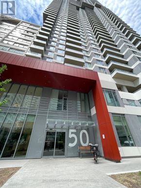 Toronto (Mount Pleasant East) condo for rent - A tall building with a red and white facade and a glass entrance.