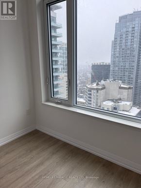 Toronto (Mount Pleasant East) condo for rent - A room with a window overlooking a cityscape.