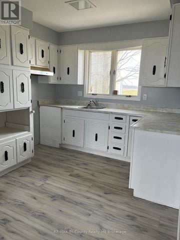 South-West Oxford apartment for rent - A kitchen with white cabinets and a marble countertop.