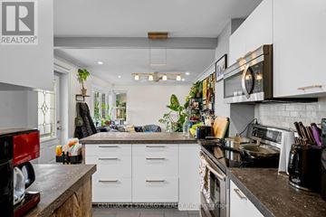Ottawa duplex for rent - A kitchen with white cabinets and a black counter top.