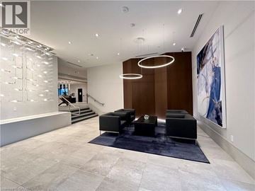Grimsby condo for rent - A modern living room with a black sofa and a large painting on the wall.