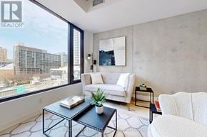 Toronto (Moss Park) condo for rent - A living room with a large window overlooking a cityscape.