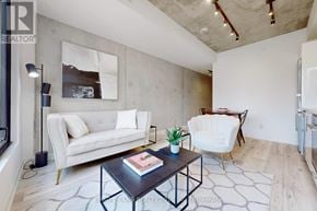 Toronto (Moss Park) condo for rent - A living room with a white couch, a coffee table, and a chair.
