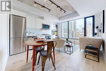 Toronto (Moss Park) condo for rent - A modern kitchen with a dining table and chairs.