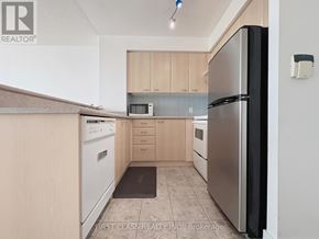 Toronto (Woburn) condo for rent - A kitchen with a refrigerator, microwave, and oven.