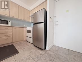 Toronto (Woburn) condo for rent - A kitchen with a refrigerator, microwave, and oven.