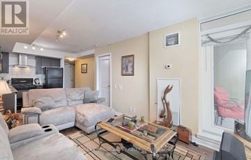 Toronto (Bendale) condo for rent - A living room with a grey couch and a glass coffee table.