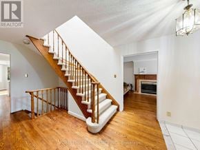 Markham (Unionville) apartment for rent - A wooden staircase with white steps and railings leads to a second floor.