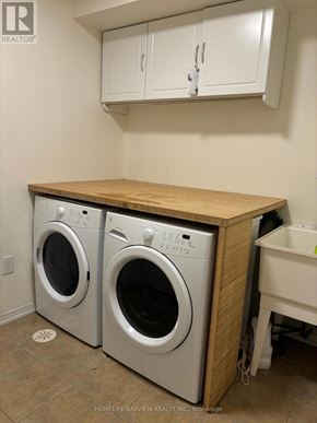 Markham (Berczy) townhouse for rent - A laundry room with two front loading washing machines.