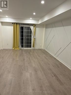 Markham (Berczy) townhouse for rent - A room with wooden flooring and a window with yellow curtains.