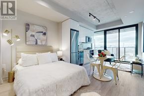 Toronto (Kensington-Chinatown) condo for rent - A bedroom with a large bed and a dining area with a table and chairs.