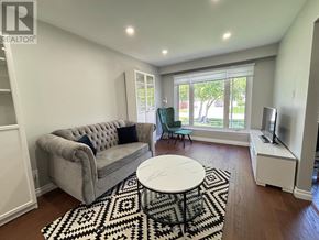 Milton (Dp Dorset Park) apartment for rent - A living room with a grey couch, a white coffee table, and a black and white rug.