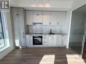 Toronto (Banbury-Don Mills) condo for rent - A modern kitchen with white cabinets and a wooden floor.