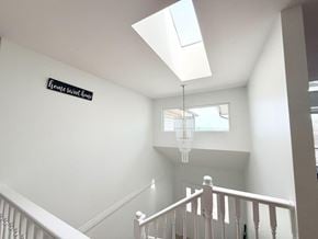 Surrey apartment for rent - A white staircase with a chandelier hanging from the ceiling.
