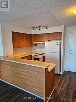 Toronto (Woburn) condo for rent - A kitchen with wooden cabinets and a white refrigerator.