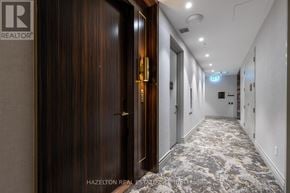 Toronto (Waterfront Communities) condo for rent - A hallway with a wooden door and a sign that says "REALTOR".