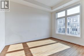 Markham (Wismer) townhouse for rent - A room with a large window and wooden flooring.