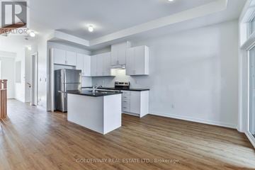 Markham (Wismer) townhouse for rent - A kitchen with white cabinets and a wooden floor.