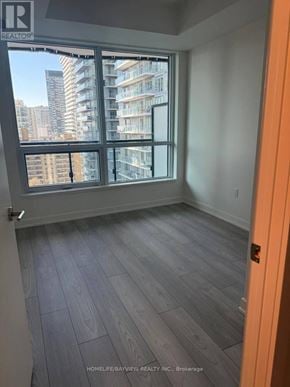 Toronto (Mount Pleasant West) condo for rent - A room with a large window overlooking a cityscape.