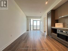 Vaughan (Vaughan Corporate Centre) condo for rent - A room with wooden flooring and a kitchen area with a stove top oven.